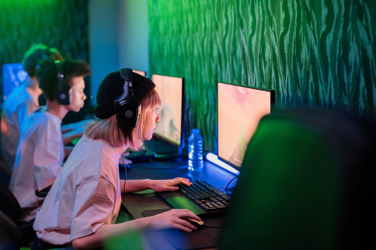 Gamers intensely focused on playing in a vibrant cybercafe environment.